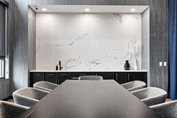 a meeting room with a table and chairs and a marble wall